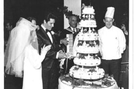 elvis and priscilla presley standing in front of their wedding cake