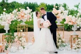 beautiful bride and groom in the wedding ceremony area of live white and pink flowers. decoration and organization of celebrations in the open air.