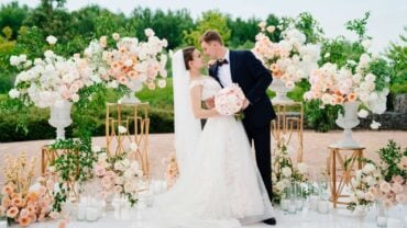 beautiful bride and groom in the wedding ceremony area of live white and pink flowers. decoration and organization of celebrations in the open air.