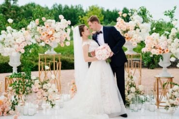 beautiful bride and groom in the wedding ceremony area of live white and pink flowers. decoration and organization of celebrations in the open air.